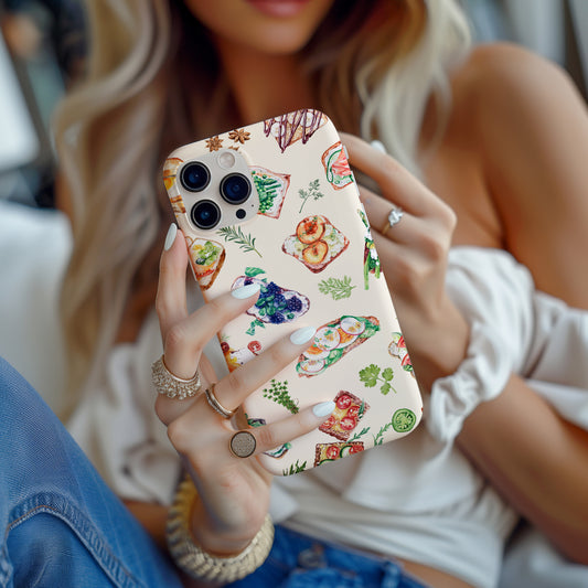 girl holding Sandwich Collage Phone Case is uniquely designed with delicate watercolor collage art. Available for both iPhone and Samsung Galaxy, this case artfully combines elements of open faced sandwiches with delicate herbs. Great foodie or chef gift by Artscape Market